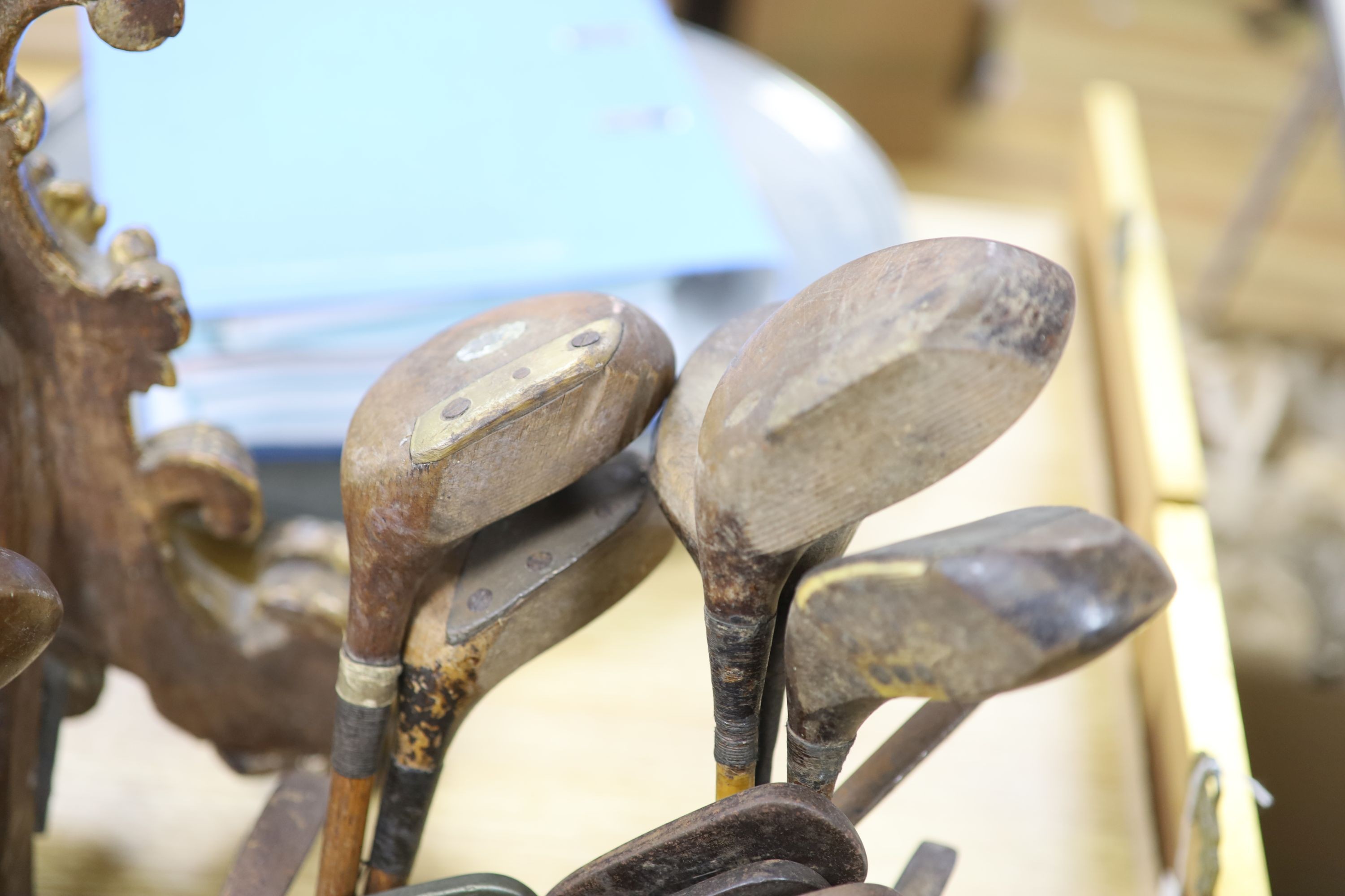 A collection of pre-war golfing irons and woods, contained within three canvas golf bags